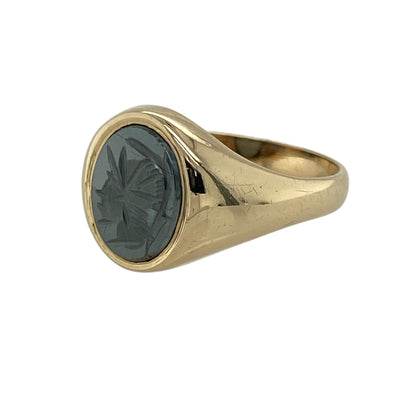 Add sleek sophistication and understated style to your collection with this pre-owned 9ct yellow gold and hematite oval signet ring, combining classic design with a modern edge—perfect for both everyday wear and special occasions.

Design: The ring features a polished oval hematite stone measuring 10mm by 8mm, showcasing its distinctive metallic grey sheen and mirror-like finish.