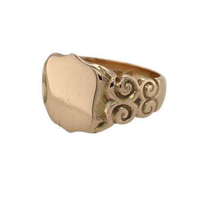 Bring vintage charm and refined craftsmanship to your collection with this pre-owned 9ct rose gold shield signet ring—a distinctive piece blending tradition with timeless style.

Design: The ring features a classic shield-shaped front measuring 13mm high, complemented by intricately scroll-patterned shoulders that add an elegant vintage touch.
Material: Made from 9-carat rose gold, the warm pink hue enhances the antique-inspired design and gives the ring a rich, sophisticated appearance.