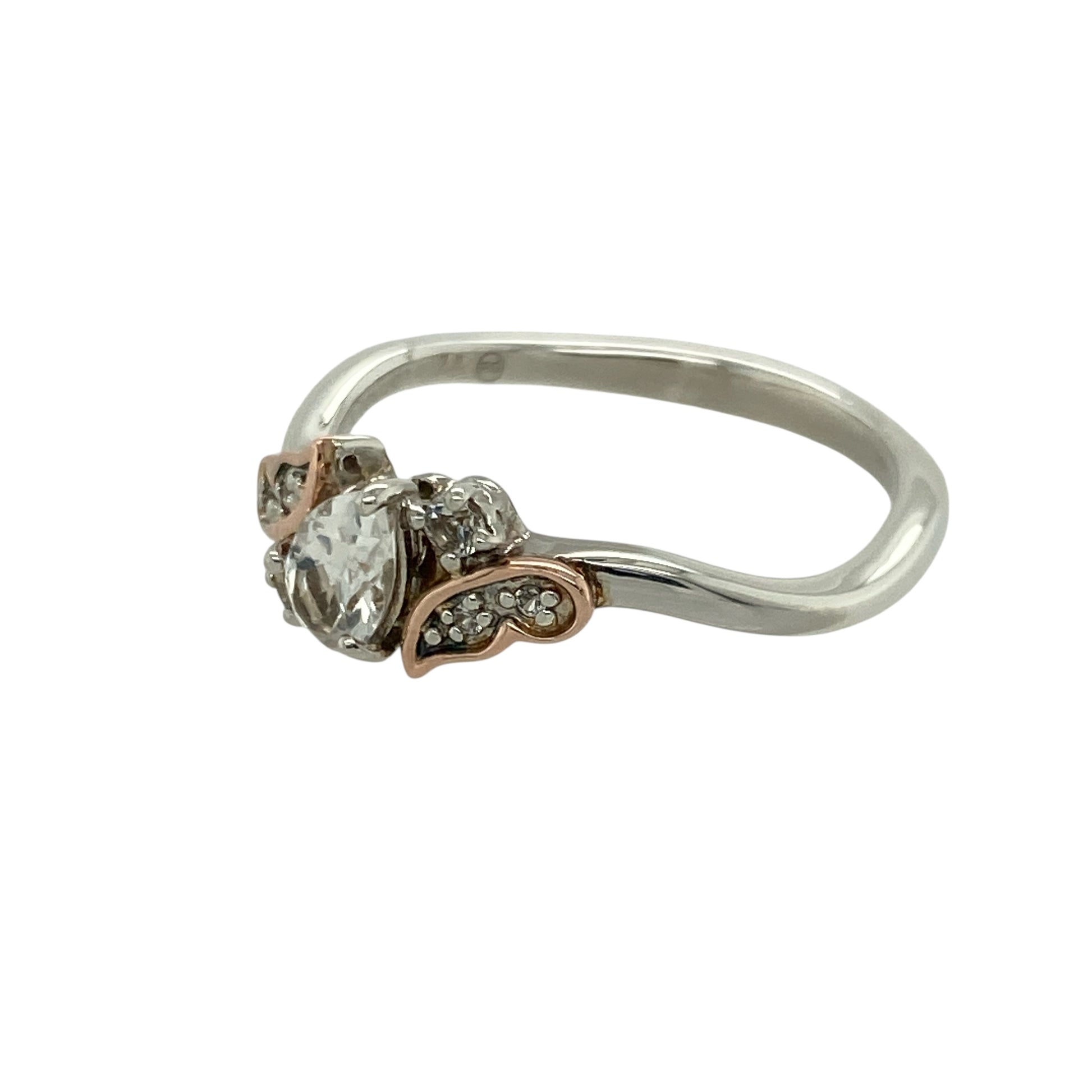 Bring graceful sparkle and contemporary elegance to your collection with this pre-owned 925 silver with 9ct rose gold and white topaz set Clogau teardrop ring—a beautifully feminine design inspired by timeless sophistication.

Design: The ring features a 6mm by 4mm teardrop-shaped white topaz at the centre, radiating brilliance and complemented by Clogau’s signature rose gold detailing.