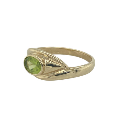 Add a touch of vibrant colour and elegant design to your collection with this pre-owned 9ct yellow gold oval peridot swirl ring, blending timeless style with a refreshing pop of green—perfect for everyday wear or special occasions.

Design: The ring features a 7mm by 5mm oval-cut peridot at the centre, displaying a bright, lively green hue. The elegant swirl design adds movement and sophistication, beautifully framing the gemstone.
