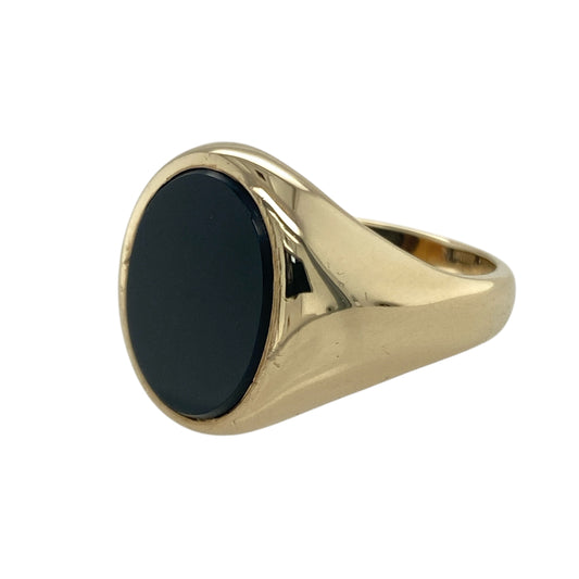 Bring bold elegance and vintage charm to your collection with this pre-owned 9ct yellow gold and onyx oval signet ring—an eye-catching piece that blends classic styling with striking contrast.

Design: Featuring a polished 16mm by 12mm oval onyx stone, the ring offers a deep black focal point with a strong and traditional signet profile.
Material: Made in 9-carat yellow gold, the warm tone of the band enhances the richness of the onyx for a refined finish.