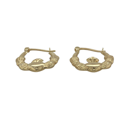 Bring meaningful symbolism and timeless charm to your collection with these pre-owned 9ct yellow gold Claddagh creole earrings—an elegant pair inspired by heritage and tradition.

Design: Featuring a classic creole hoop adorned with the iconic Claddagh motif—hands for friendship, a heart for love, and a crown for loyalty—these earrings offer a distinctive and heartfelt focal point.
Material: Made in 9-carat yellow gold, the polished finish highlights the intricate detailing with a warm, radiant shine.