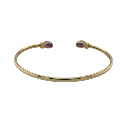 Bring vibrant colour and elegant style to your collection with this pre-owned 9ct yellow gold amethyst torque bangle—an eye-catching piece with timeless appeal.

Design: Featuring an open torque style finished with two 7mm by 5mm oval amethyst stones, the bangle offers a striking pop of purple that creates a refined and balanced focal point.
Material: Made in 9-carat yellow gold, the polished surface provides a warm contrast that enhances the richness of the amethysts.