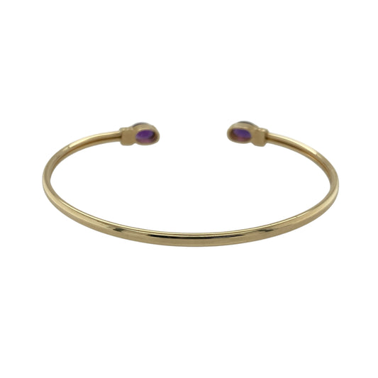 Bring vibrant colour and elegant style to your collection with this pre-owned 9ct yellow gold amethyst torque bangle—an eye-catching piece with timeless appeal.

Design: Featuring an open torque style finished with two 7mm by 5mm oval amethyst stones, the bangle offers a striking pop of purple that creates a refined and balanced focal point.
Material: Made in 9-carat yellow gold, the polished surface provides a warm contrast that enhances the richness of the amethysts.