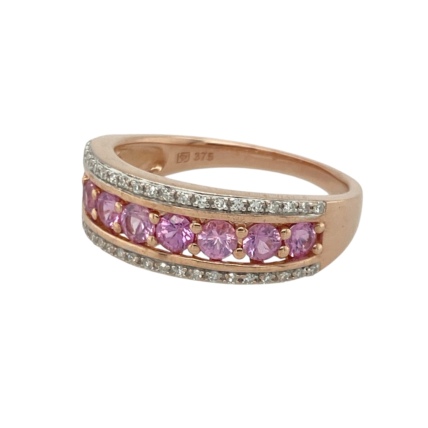Bring soft colour and refined sparkle to your collection with this pre-owned 9ct rose gold diamond and pink sapphire band ring—an elegant piece offering romantic tones and timeless charm.

Design: This size Q band features a 7mm wide front adorned with 3mm round pink sapphires, enhanced by delicate diamonds that add brightness and balance to the design.
Material: Made from 9-carat rose gold, the warm blush tone beautifully complements the vivid pink sapphires and the gentle sparkle of the diamonds.