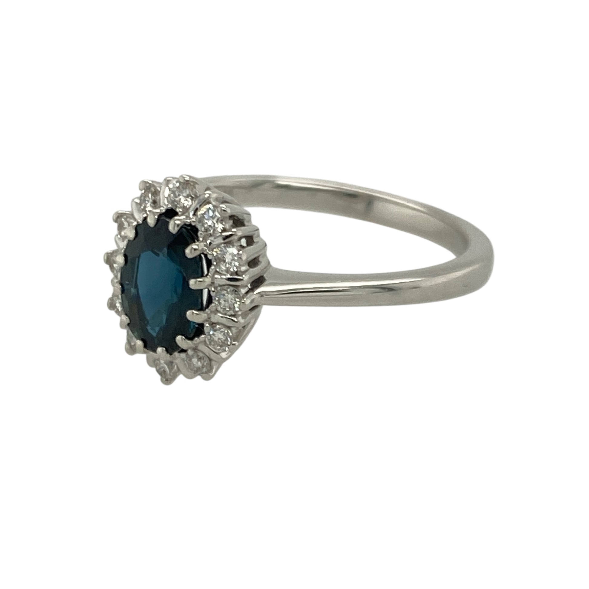Bring rich colour and classic sparkle to your collection with this pre-owned 18ct white gold diamond and sapphire cluster ring—an elegant piece offering timeless beauty and refined brilliance.

Design: This size K–L ring features a 7mm by 5mm oval sapphire at the centre, surrounded by a halo of diamonds that enhance the sapphire’s deep blue tone with bright, eye-catching sparkle.