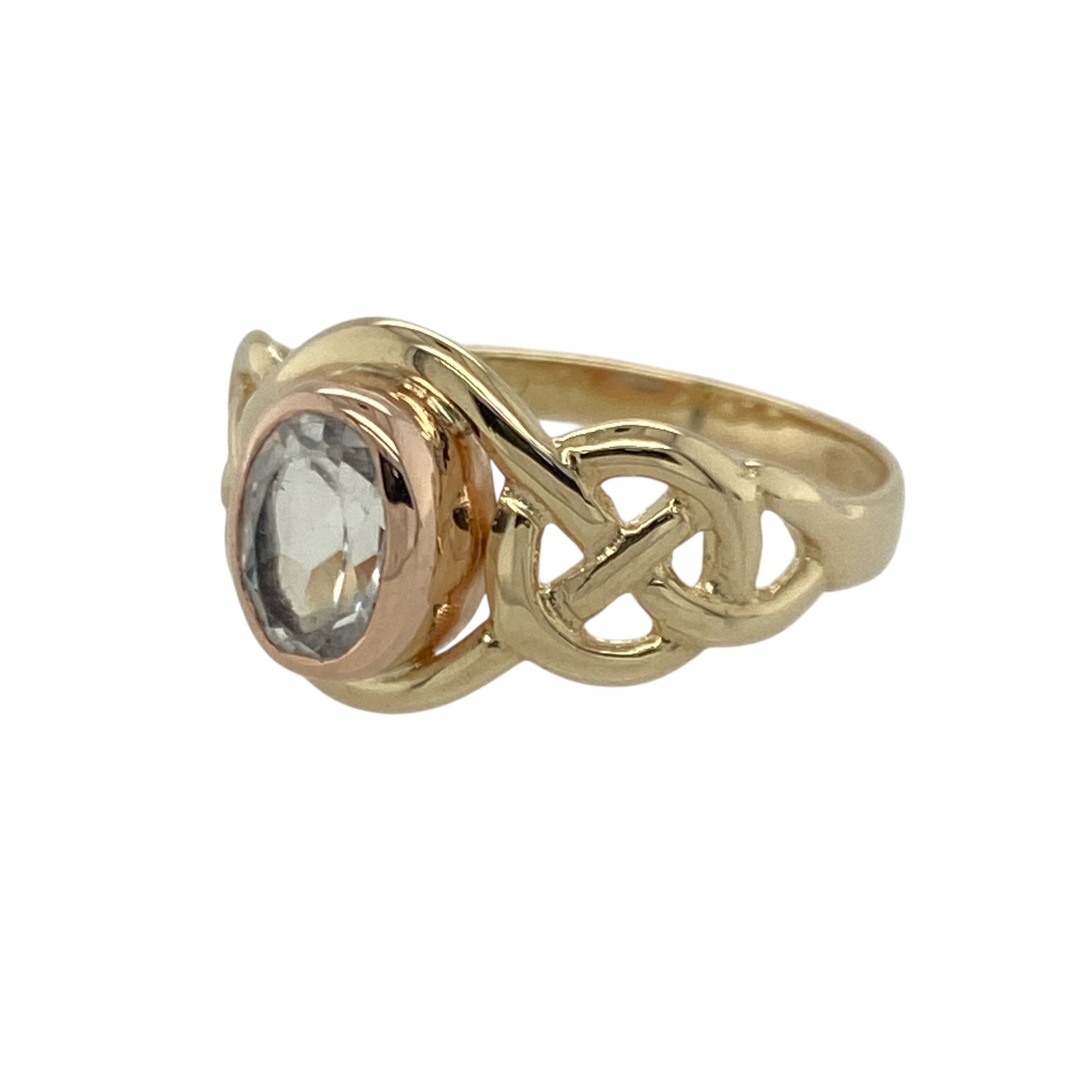 Bring meaningful design and vibrant colour to your collection with this pre-owned 9ct yellow and rose gold Clogau knot ring—an elegant piece offering symbolic style and refined gemstone beauty.

Design: This size M ring features a 7mm by 5mm oval topaz at the centre, framed by a flowing Clogau knot motif that represents unity, continuity, and connection.
Material: Made from 9-carat yellow and rose gold, the warm mixed-metal tones beautifully complement the bright, crisp blue of the topaz.