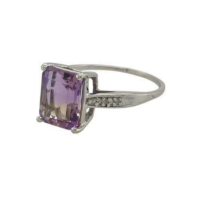 Bring captivating colour and refined sparkle to your collection with this pre-owned 9ct white gold ametrine and diamond ring—an elegant piece offering unique beauty and timeless sophistication.

Design: This size S ring features a striking 10mm by 8mm ametrine at the centre, displaying its natural blend of purple amethyst and golden citrine tones, complemented by diamonds that add bright, balanced sparkle.