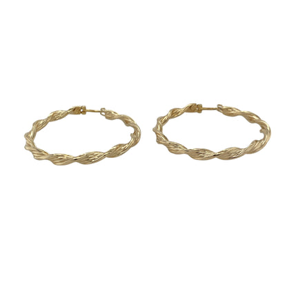 Bring graceful movement and warm golden shine to your collection with these pre-owned 9ct yellow gold ribbon-twisted creole earrings—an elegant pair offering timeless style and refined detail.

Design: These hoop creole earrings feature a flowing ribbon-twist pattern, creating soft curves and light-catching texture for a beautifully feminine look.
Material: Made from 9-carat yellow gold, the polished surfaces enhance their rich golden tone and highlight the twisting design.