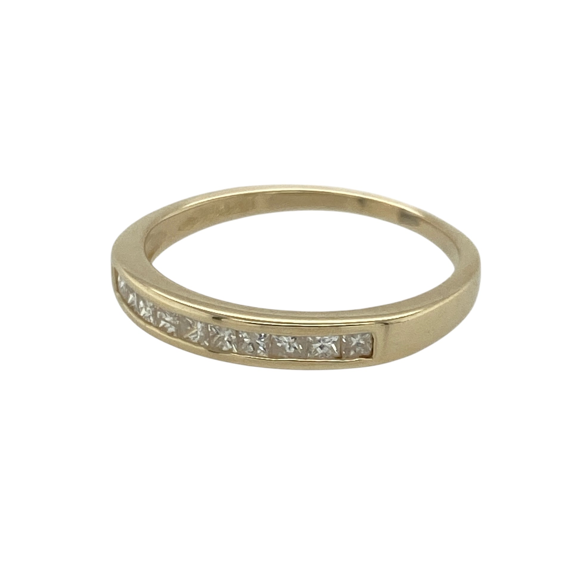 Bring refined sparkle and classic elegance to your collection with this pre-owned 9ct yellow gold diamond band ring—an attractive piece offering timeless style and subtle brilliance.

Design: This size L–M band features a 3mm wide front with ten princess-cut diamonds set neatly inside the band, creating a sleek, modern line of sparkle.
Material: Made from 9-carat yellow gold, the polished finish enhances its warm tone and highlights the clean geometric edges of the princess-cut stones.