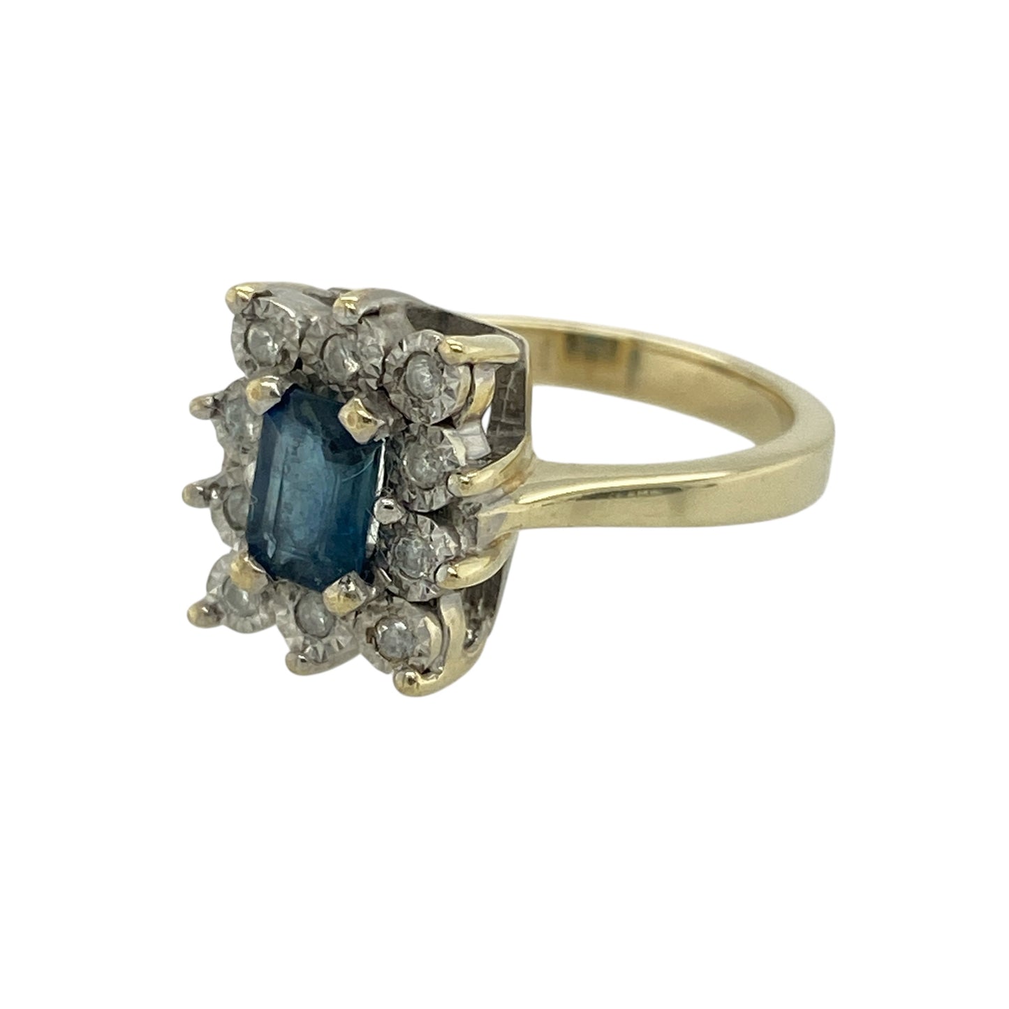 Bring rich colour and elegant sparkle to your collection with this pre-owned 9ct yellow and white gold sapphire and diamond cluster ring—an attractive piece offering timeless beauty and refined detail.

Design: This size K ring features a 6mm by 4mm emerald-cut sapphire at the centre, surrounded by illusion-set diamonds that enhance its deep blue tone with subtle, balanced sparkle.