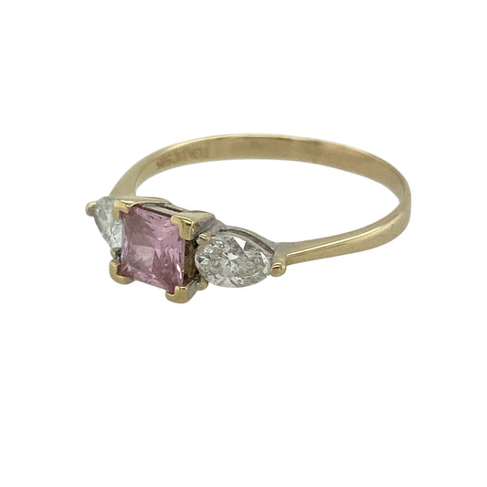 Bring vibrant colour and elegant sparkle to your jewellery collection with this pre-owned 14ct yellow gold diamond and pink topaz coloured trilogy ring — perfect for meaningful moments or refined everyday wear.

Design: At the centre sits a 5mm by 5mm princess-cut pink topaz coloured stone, framed by two pear-cut diamonds of approximately 0.25ct each, forming a striking and balanced trilogy arrangement.
