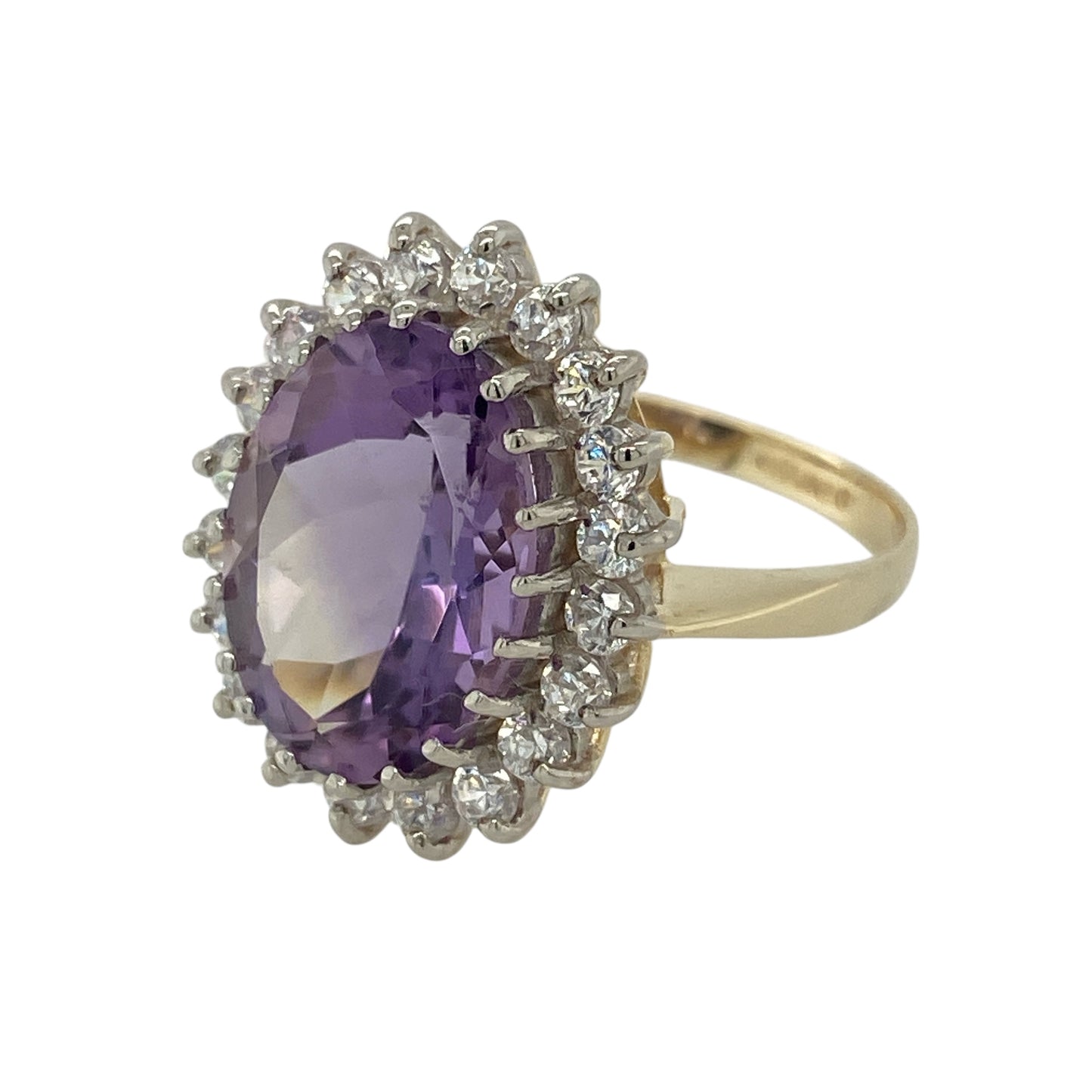 Bring bold colour and timeless elegance to your collection with this pre-owned 9ct yellow gold amethyst and cubic zirconia cluster ring—an impressive piece with striking presence and refined sparkle.

Design: This standout cluster ring features a generous 14mm by 10mm oval amethyst at the centre, offering deep purple richness and a dramatic focal point. Surrounding cubic zirconia stones add bright contrast and enhance the gemstone’s brilliance, creating a classic and eye-catching silhouette.