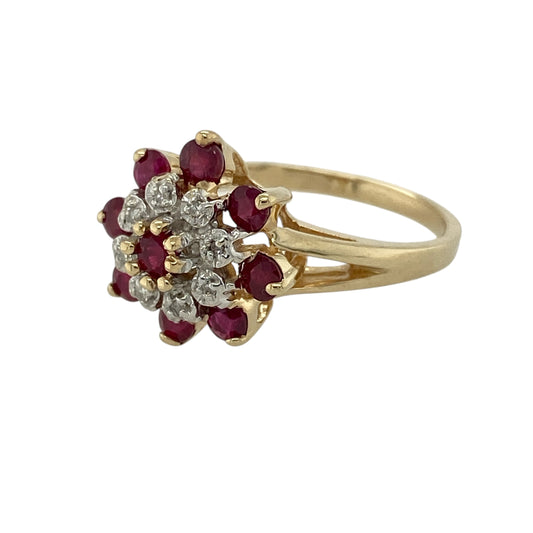 Bring rich colour and striking sparkle to your collection with this pre-owned 9ct yellow gold diamond and ruby cluster ring—an impressive piece with bold presence and timeless elegance.

Design: Standing 15mm high at the front, this eye-catching cluster ring features a central ruby surrounded by a row of bright diamonds, with an additional outer ring of rubies completing the design. The layered arrangement creates a dramatic, floral-inspired silhouette with beautiful contrast and depth.
