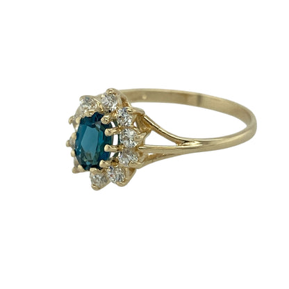 Bring bright colour and classic sparkle to your collection with this pre-owned 9ct yellow gold blue topaz and cubic zirconia cluster ring—an elegant piece with timeless, refreshing beauty.

Design: This refined cluster ring features a 6mm by 4mm oval blue topaz at the centre, offering vivid, uplifting colour. Surrounding cubic zirconia stones add gentle brilliance, creating a traditional and eye-catching cluster silhouette.