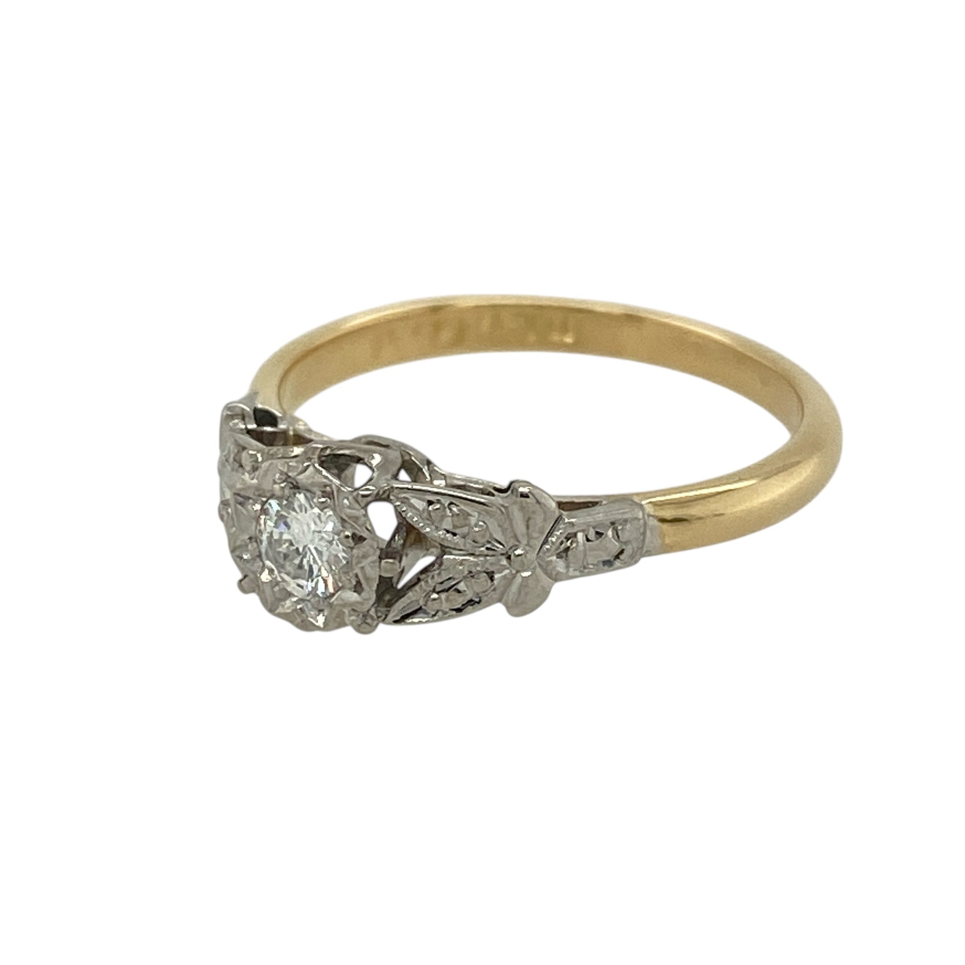 Bring timeless elegance and vintage character to your collection with this pre-owned 18ct yellow gold and platinum diamond solitaire ring—an exquisite Art Deco–inspired piece with classic period detail.

Design: This vintage-style solitaire ring reflects the refined aesthetics of the 1920s–1930s, featuring elegant leaf-like detailing along the shoulders—an iconic design element of the Art Deco era. The diamond sits proudly at the centre, enhanced by the delicate, flowing metalwork.