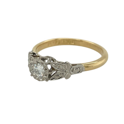 Bring timeless elegance and vintage character to your collection with this pre-owned 18ct yellow gold and platinum diamond solitaire ring—an exquisite Art Deco–inspired piece with classic period detail.

Design: This vintage-style solitaire ring reflects the refined aesthetics of the 1920s–1930s, featuring elegant leaf-like detailing along the shoulders—an iconic design element of the Art Deco era. The diamond sits proudly at the centre, enhanced by the delicate, flowing metalwork.
