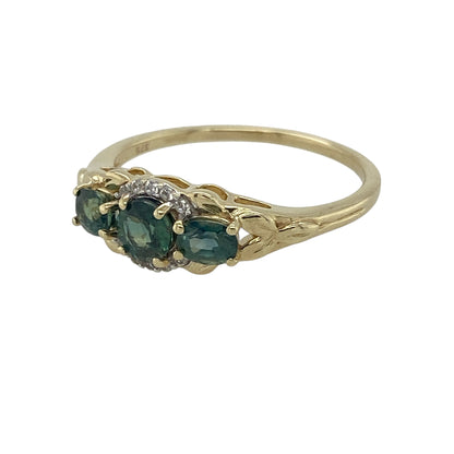 Bring fresh colour and elegant sparkle to your jewellery collection with this pre-owned 9ct yellow gold green stone & cubic zirconia set trilogy ring, offering a classic design with added brilliance.

Design: The ring features a traditional trilogy arrangement, with a central green stone flanked by two matching green stones, creating a balanced and eye-catching look.
Material: Made from 9-carat yellow gold