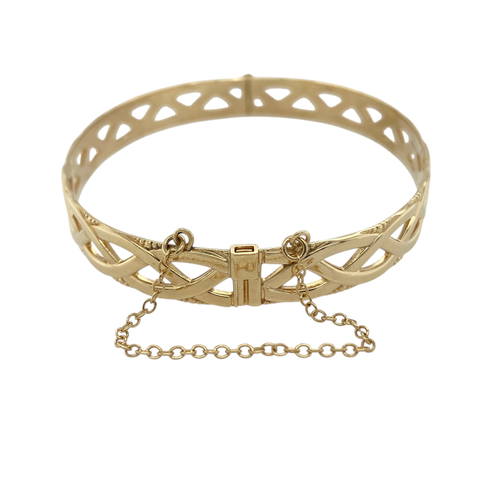 Bring elegant texture and classic craftsmanship to your jewellery collection with this pre-owned 9ct yellow gold open weave bangle, offering a bold yet refined design.

Design: The bangle features an open weave pattern, creating depth and visual interest while allowing light to pass through the design for a striking effect.
Material: Made from 9-carat yellow gold, the warm polished finish enhances the woven detailing and gives the piece a rich golden glow.