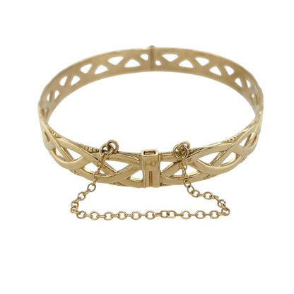 Bring elegant texture and classic craftsmanship to your jewellery collection with this pre-owned 9ct yellow gold open weave bangle, offering a bold yet refined design.

Design: The bangle features an open weave pattern, creating depth and visual interest while allowing light to pass through the design for a striking effect.
Material: Made from 9-carat yellow gold, the warm polished finish enhances the woven detailing and gives the piece a rich golden glow.