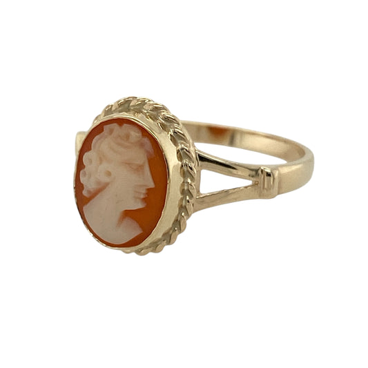 Bring vintage charm and classic elegance to your jewellery collection with this pre-owned 9ct yellow gold & cameo set ring, offering timeless style with beautiful detail.

Design: The ring features a traditional oval cameo as the focal point, framed by a decorative rope-style surround that enhances its classic and refined appearance.
Material: Made from 9-carat yellow gold, the warm polished finish beautifully complements the soft tones of the cameo and the intricate rope detailing.