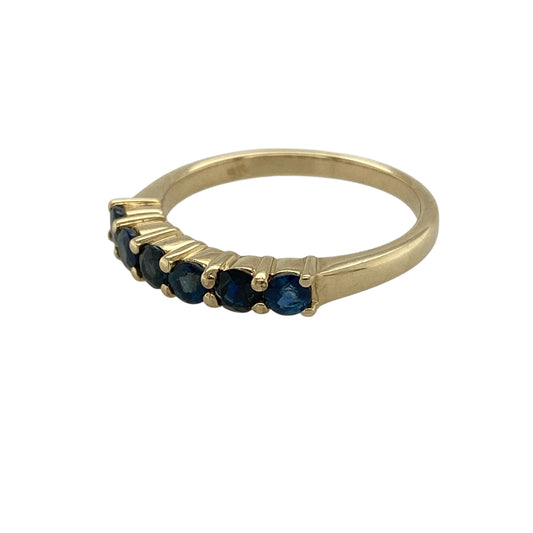 Bring rich colour and classic elegance to your jewellery collection with this pre-owned 9ct gold sapphire six stone band ring, a refined design that blends timeless style with vibrant gemstone detail—perfect for everyday wear or special occasions.

Design: The ring features a straight band front displaying six round sapphires arranged in a neat row, creating a balanced and eye-catching look. Each sapphire measures approximately 3mm in diameter, offering vivid colour with a refined profile.