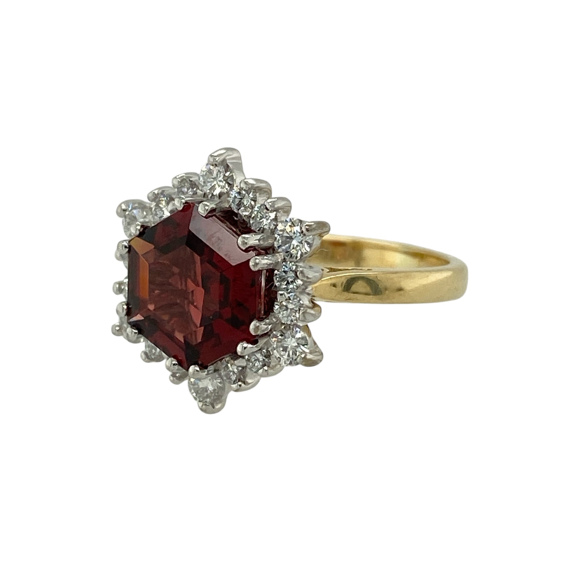 Bring rich colour and classic sparkle to your jewellery collection with this pre-owned 18ct yellow gold diamond and garnet set cluster ring, a striking design that combines bold gemstone presence with timeless elegance.

Design: The ring features a centrally placed garnet in a distinctive hexagonal shape, measuring approximately 5mm on each of its six sides. Surrounding diamonds form a radiant cluster, enhancing the deep red tones of the garnet and creating an eye-catching focal point.