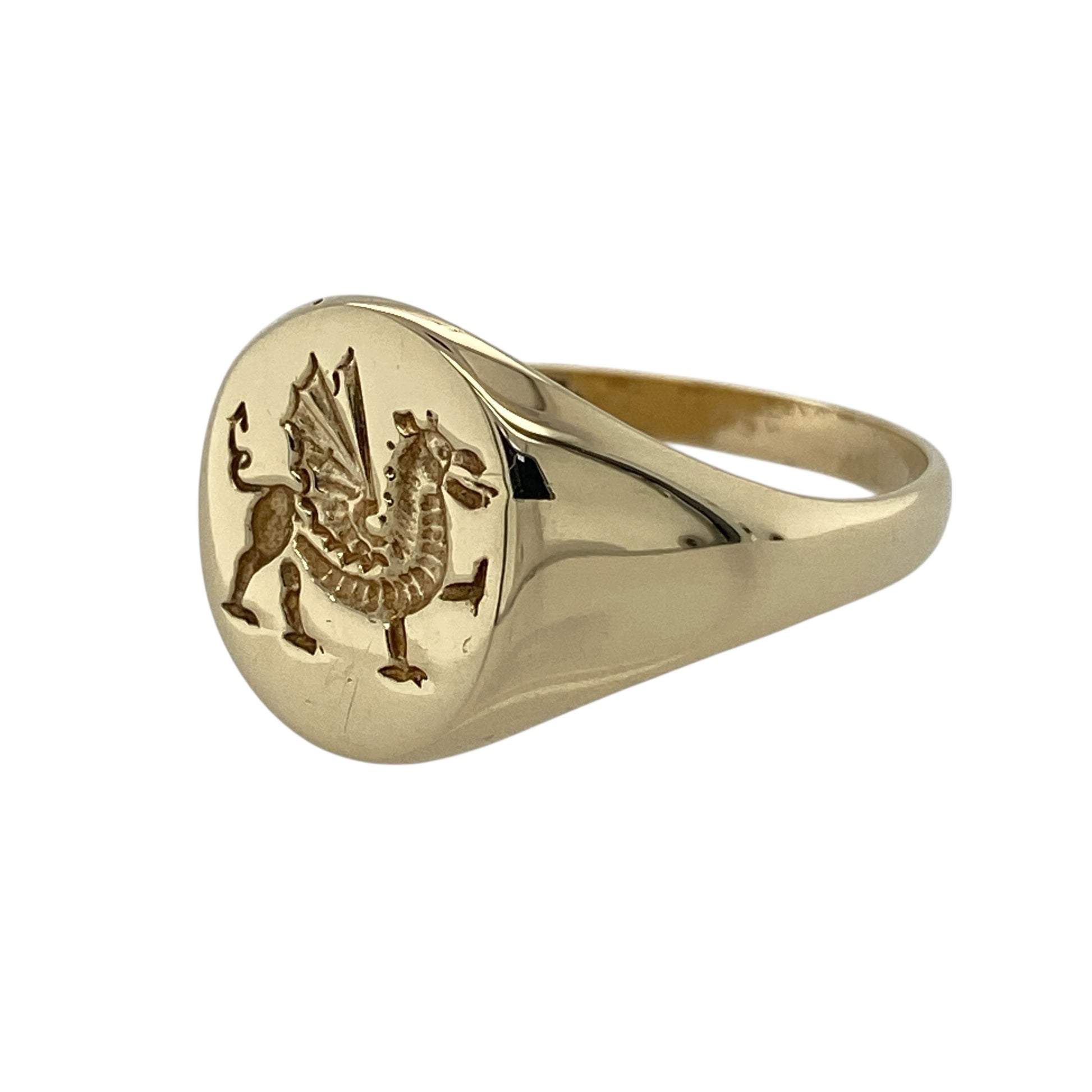 Bring bold character and traditional symbolism to your jewellery collection with this pre-owned 9ct yellow gold Welsh dragon oval signet ring, a striking piece that celebrates heritage with timeless style.

Design: The ring features an oval signet face engraved with the iconic Welsh dragon, with the front measuring 14mm high for a strong and confident presence.
Material: Made from polished 9-carat yellow gold, the warm tone enhances the detailed dragon motif and classic signet form.