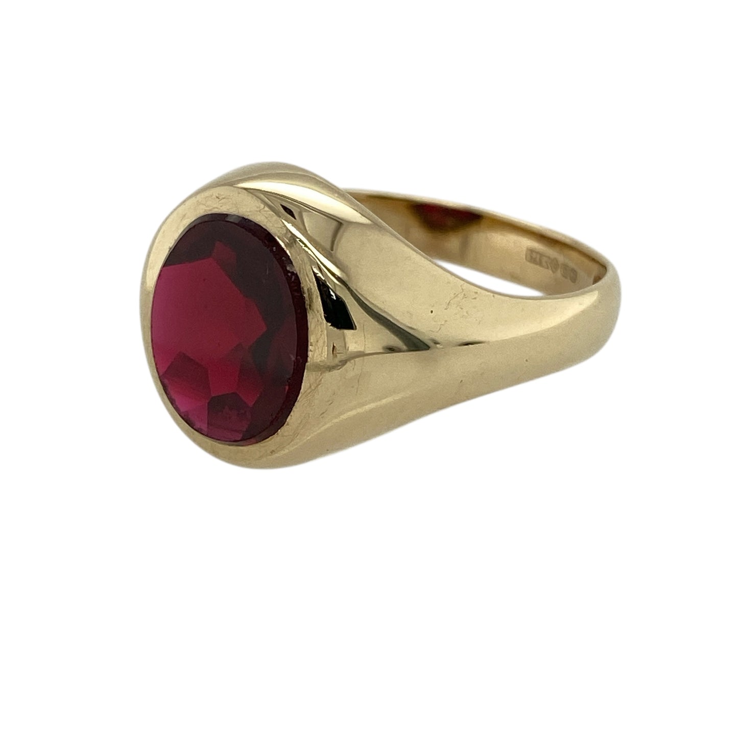 Bring bold colour and classic signet style to your jewellery collection with this pre-owned 9ct yellow gold red stone oval signet ring, a striking piece that combines traditional design with rich, eye-catching detail.

Design: The ring features an oval red stone with a ruby-coloured hue measuring 11mm by 9mm, forming a strong and elegant focal point within the signet-style face.