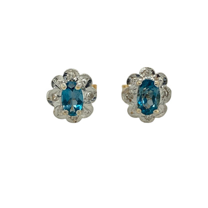 Bring delicate charm and soft colour to your jewellery collection with these pre-owned 9ct yellow and white gold diamond & blue topaz set flower stud earrings, a beautifully balanced design with timeless appeal.

Design: Each stud features a floral-inspired arrangement centred with an oval blue topaz measuring 4mm by 3mm, complemented by diamond accents that add gentle sparkle.