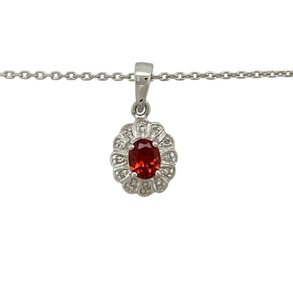 Bring rich colour and refined sparkle to your jewellery collection with this pre-owned 9ct white gold diamond & garnet cluster pendant necklace, a timeless design with elegant contrast and classic appeal.

Design: The pendant features an oval garnet measuring 5mm by 4mm, surrounded by a cluster of diamonds that enhance the depth of colour and add radiant sparkle. The pendant measures 1.7cm long including the bail, creating a delicate yet eye-catching focal point.