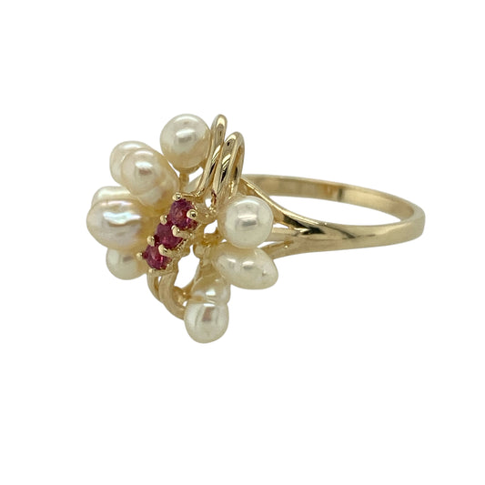 Bring vintage-inspired charm and elegant contrast to your jewellery collection with this pre-owned 9ct yellow gold ruby & pearl set dress ring, a beautifully detailed piece with classic appeal.

Design: The ring features a decorative front measuring 17mm high, centred with three small rubies, flanked by nine pearls flowing out to either side to create a graceful and eye-catching arrangement.