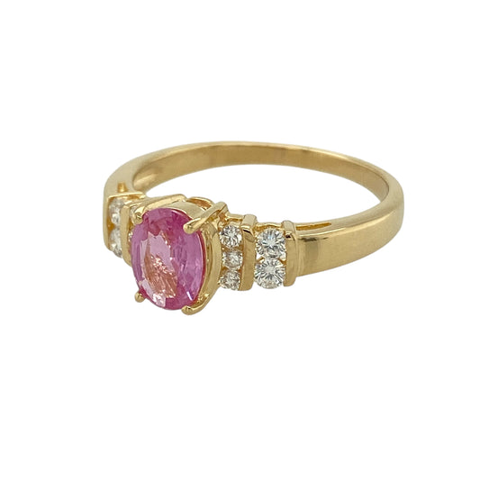 Bring refined colour and luxurious sparkle to your jewellery collection with this pre-owned 18ct yellow gold diamond & pink sapphire set ring, an elegant design with striking detail and timeless appeal.

Design: The ring features an oval pink sapphire measuring 7mm by 5mm as its centrepiece, beautifully framed by two rows of brilliant-cut diamonds on either side, creating a rich and eye-catching focal point.