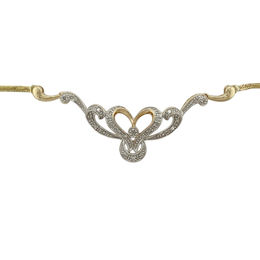 Bring romantic movement and elegant sparkle to your jewellery collection with this pre-owned 9ct yellow gold diamond set heart swirl necklace, a graceful design with timeless appeal.

Design: The necklace features a flowing heart swirl motif accented with diamonds, creating a soft and elegant focal point with gentle sparkle.
Material: Made from polished 9-carat yellow gold, the warm tone beautifully complements the diamond detailing and fluid heart design.