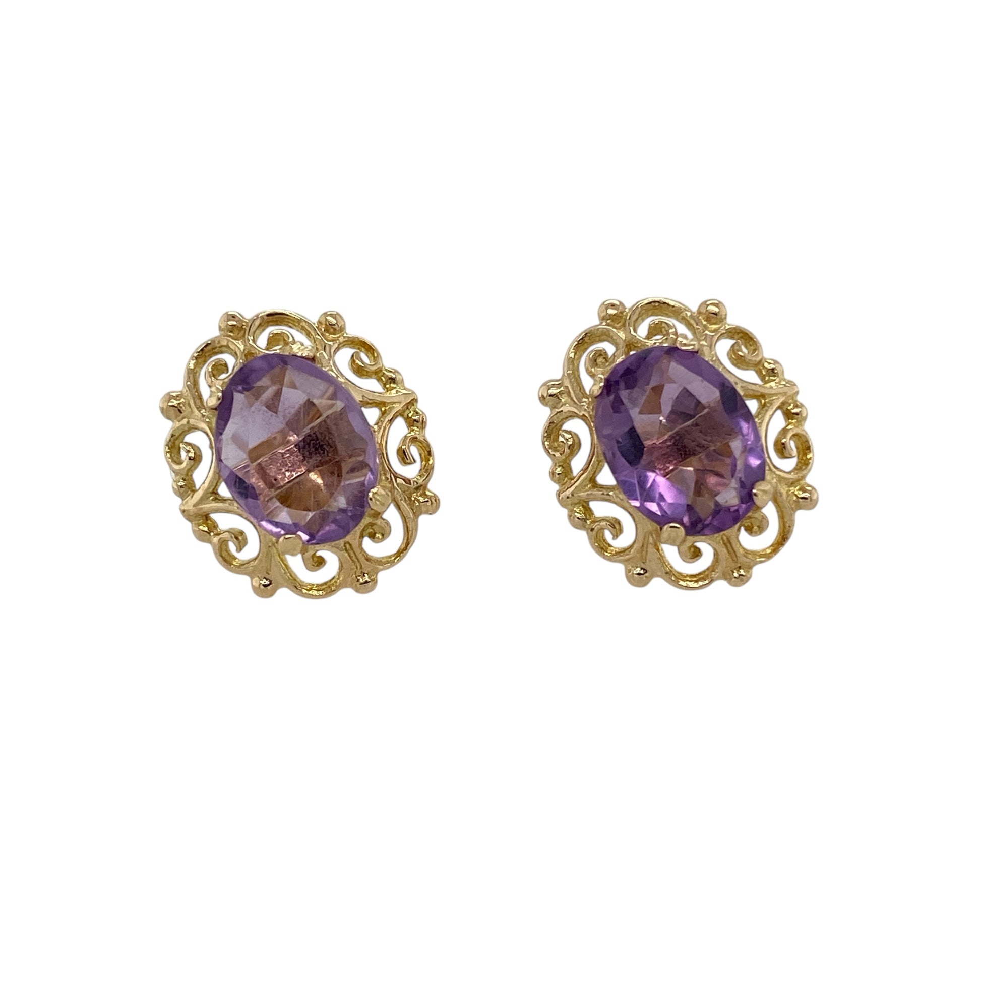 Bring rich colour and ornate detail to your jewellery collection with these pre-owned 9ct yellow gold amethyst set fancy scroll patterned stud earrings, a striking design with vintage-inspired charm.

Design: Each stud features an oval amethyst stone measuring 9mm by 7mm, framed by an intricate scroll-patterned setting that creates an elegant and decorative focal point.
Material: Made from polished 9-carat yellow gold, the warm tone beautifully complements the deep purple hue of the amethysts.