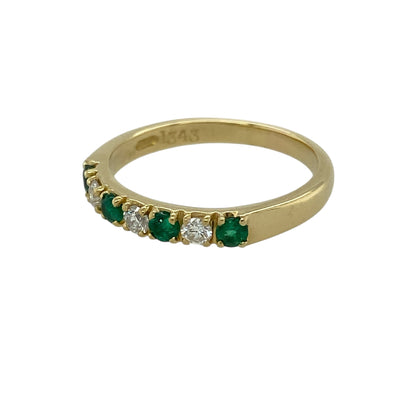 Bring rich colour and classic luxury to your jewellery collection with this pre-owned 18ct yellow gold diamond and emerald set band ring, an elegant piece with timeless appeal.

Design: This ring features a refined band style adorned with vivid round emeralds, complemented by diamond accents that add balance and subtle sparkle across the front.
Material: Made from luxurious 18-carat yellow gold, the warm golden tone beautifully enhances the vibrant green of the emeralds and the brilliance of the diamonds.