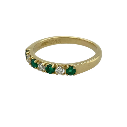 Bring rich colour and classic luxury to your jewellery collection with this pre-owned 18ct yellow gold diamond and emerald set band ring, an elegant piece with timeless appeal.

Design: This ring features a refined band style adorned with vivid round emeralds, complemented by diamond accents that add balance and subtle sparkle across the front.
Material: Made from luxurious 18-carat yellow gold, the warm golden tone beautifully enhances the vibrant green of the emeralds and the brilliance of the diamonds.