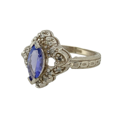 Bring elegant colour and intricate detail to your jewellery collection with this pre-owned 14ct white gold diamond and tanzanite set ornate ring, a striking piece with refined character.

Design: The ring showcases a marquise-cut tanzanite at the centre, framed by decorative detailing and diamond accents that enhance its graceful, elongated shape and add refined sparkle.