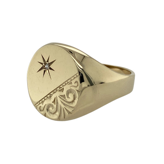 Bring bold character and refined detail to your jewellery collection with this pre-owned 9ct yellow gold diamond set patterned corner oval signet ring, a striking piece with classic styling.

Design: This ring features a traditional oval signet head with a distinctive patterned corner design, accented by diamond detailing for subtle sparkle and added sophistication.
Material: Made from 9-carat yellow gold, the warm polished finish enhances the ring’s strong silhouette and decorative detail.