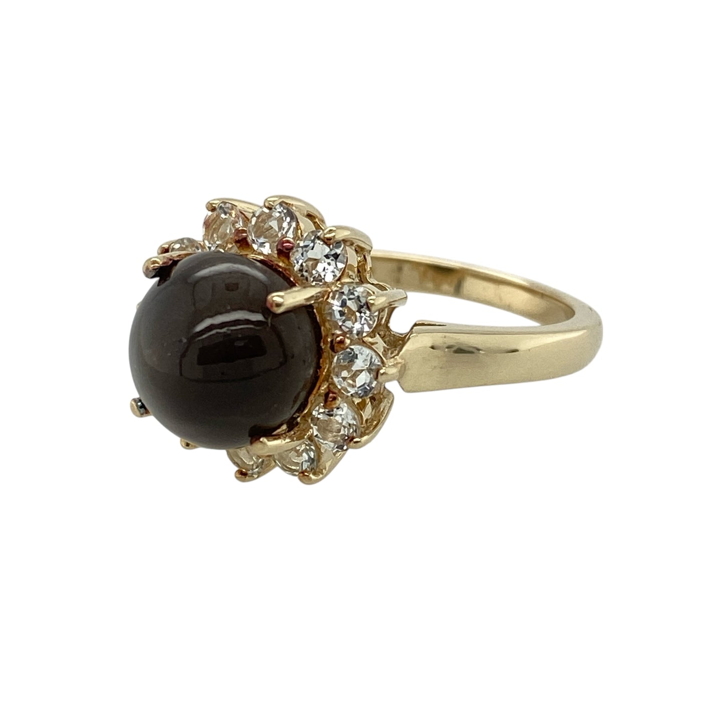 Bring distinctive light play and elegant sparkle to your jewellery collection with this pre-owned 9ct yellow gold cat’s eye and white topaz set cluster ring, a striking design with timeless appeal.

Design: This ring features a captivating round cat’s eye stone at the centre, surrounded by white topaz stones arranged in a classic cluster style that enhances brilliance and visual depth.