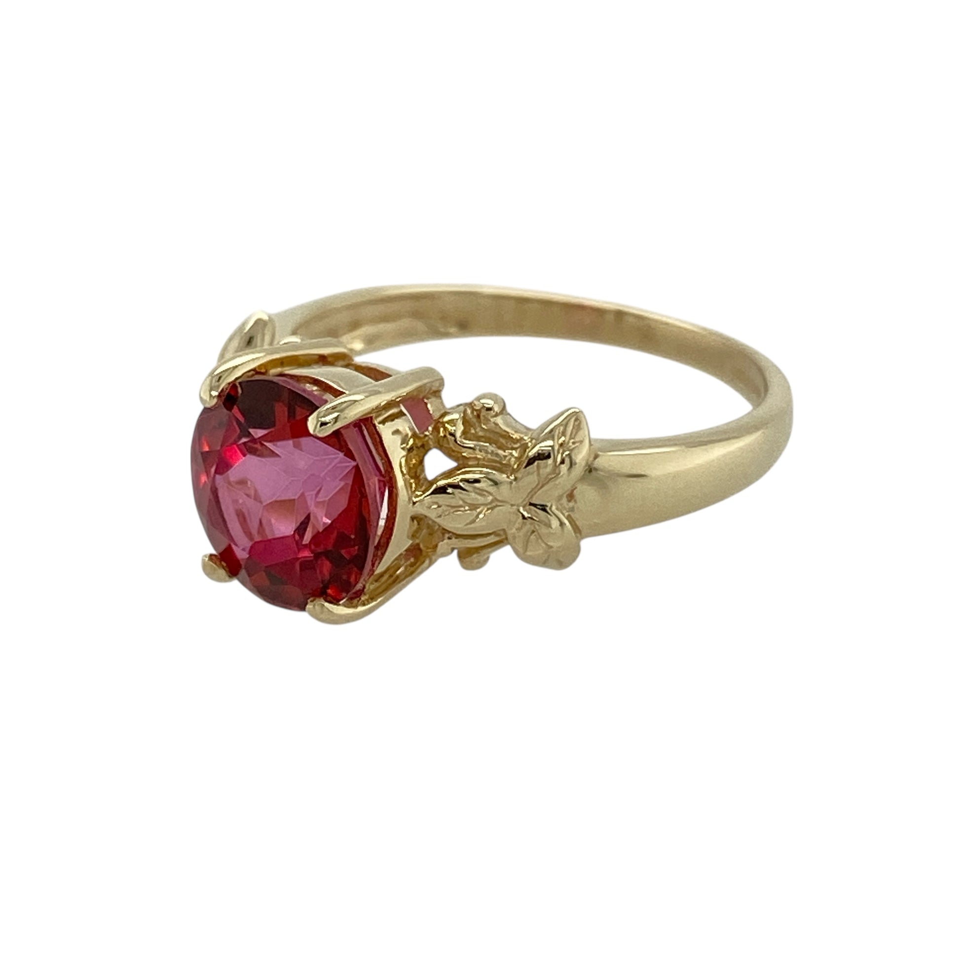 Bring warm colour and graceful detail to your jewellery collection with this pre-owned 9ct yellow gold red topaz set ring, a striking piece with elegant character.

Design: This ring features a vibrant round red topaz at the centre, complemented by leaf-style shoulders that add a decorative and nature-inspired touch to the design.
Material: Made from 9-carat yellow gold, the warm polished finish beautifully enhances the rich tones of the red topaz and the flowing shoulder detail.