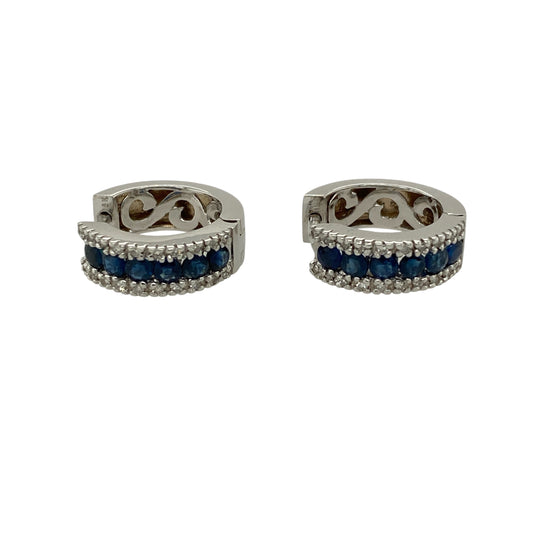 Bring classic colour and refined sparkle to your jewellery collection with these pre-owned 18ct white gold diamond and sapphire set huggie earrings.

Design: The earrings feature a timeless huggie hoop style, set with rich blue sapphires and accented with sparkling diamonds for an elegant and luxurious look.
Material: Made from 18-carat white gold, the bright polished finish enhances the brilliance of the diamonds and the deep tones of the sapphires.