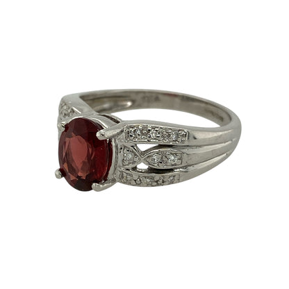 Bring rich colour and luxurious sparkle to your jewellery collection with this pre-owned 18ct white gold diamond and garnet set ring.

Design: The ring features an oval garnet-coloured centre stone measuring approximately 8mm by 6mm, creating a bold and elegant focal point.
Material: Made from 18-carat white gold, the bright polished finish beautifully enhances the deep tones of the garnet and the brilliance of the diamonds.