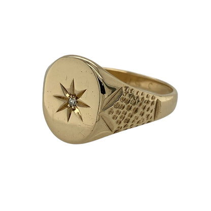 Bring bold character and striking sparkle to your jewellery collection with this pre-owned 9ct yellow gold diamond starburst set signet ring.

Design: The ring features a standout starburst motif set with a sparkling diamond at the centre, creating a strong and eye-catching focal point. The front of the ring measures approximately 14mm in height, giving it a commanding presence.
Material: Made from 9-carat yellow gold, the warm polished finish enhances the dramatic starburst design and classic signet style.