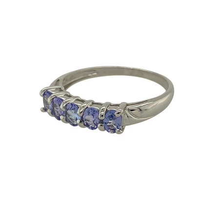 Bring rich colour and refined elegance to your jewellery collection with this pre-owned 9ct white gold tanzanite set five stone band ring, offering a timeless design with beautiful balance—perfect for everyday wear or special occasions.

Design: The ring features five oval tanzanite stones, each measuring approximately 4mm by 3mm, arranged in a classic row to create a striking and harmonious look.