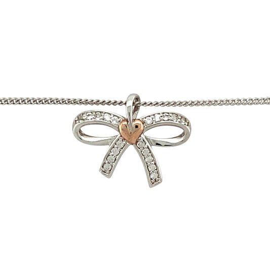 Preowned 925 Silver and 9ct Rose Gold Clogau & White Topaz Set Clogau Bow Pendant on an 18”, 20" to 22" Clogau curb chain with the weight 4.20 grams. The pendant is 1.6cm long including the bail