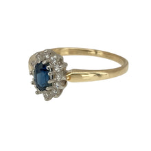 Load image into Gallery viewer, Add a touch of classic elegance to your jewellery collection with this pre-owned 9ct yellow gold diamond &amp; sapphire set cluster ring, featuring:

Design: A timeless cluster-style setting, enhancing the beauty of the central gemstone with a dazzling diamond surround.
Material: 9-carat yellow gold, offering a warm and polished finish.
Gemstone Arrangement: Showcases a rich 5mm by 3mm sapphire, radiating deep blue brilliance.
Diamond Accents: Sparkling diamonds encircle the sapphire
