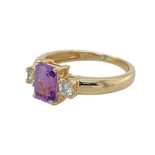 Load image into Gallery viewer, Add a touch of colour and sparkle to your jewellery collection with this pre-owned 9ct yellow gold amethyst and cubic zirconia set trilogy ring, featuring:

Design: A classic trilogy setting with a vibrant centre stone flanked by sparkling accents for a balanced and elegant look.
Material: 9-carat yellow gold, offering a warm and polished finish that enhances the gemstones.
Gemstone Detail: Features a 7mm by 5mm rectangular-cut amethyst at the centre, accented by cubic zirconia stones on either side.
