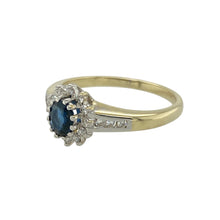 Load image into Gallery viewer, Add timeless sophistication to your collection with this pre-owned 9ct yellow gold diamond and sapphire cluster ring, featuring:

Design: A traditional cluster setting with a deep blue sapphire at the centre, surrounded by a halo of sparkling diamonds for classic elegance.
Material: 9-carat yellow gold, offering a warm, polished finish that beautifully complements the rich tone of the sapphire.
Gemstone Detail: Set with a 5mm by 4mm oval-cut sapphire, framed by brilliant-cut diamonds
