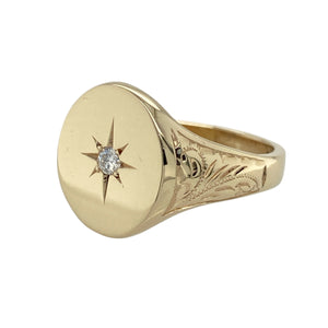 Bring bold style and refined sparkle to your collection with this pre-owned 9ct yellow gold diamond oval signet ring—perfect for making a confident statement or adding a touch of luxury to everyday wear.

Design: The ring features a 16mm high oval-shaped front with a central diamond in a starburst setting, adding both brilliance and vintage-inspired detail.
Material: Made from 9-carat yellow gold, the polished surface enhances the warm tone and highlights the intricate starburst design.
